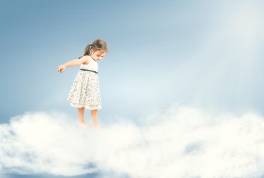 Cute little girl standing barefoot on clouds