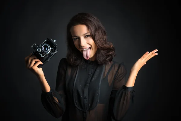 Brunette woman holding  vintage camera with open tongue — Stock Photo, Image