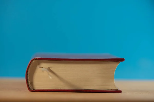 Livro Fechado Está Fundo Azul Uma Mesa Carvalho Fundo Para — Fotografia de Stock