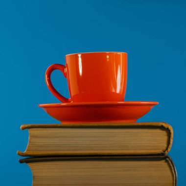 Bir yığın kitabın üzerinde kahve standı olan kırmızı bardak. Web pankartı.