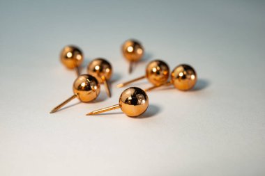  Bir grup altın renkli karatahta raptiye açık arkaplanda yatıyor. İş konsepti. Web pankartı.