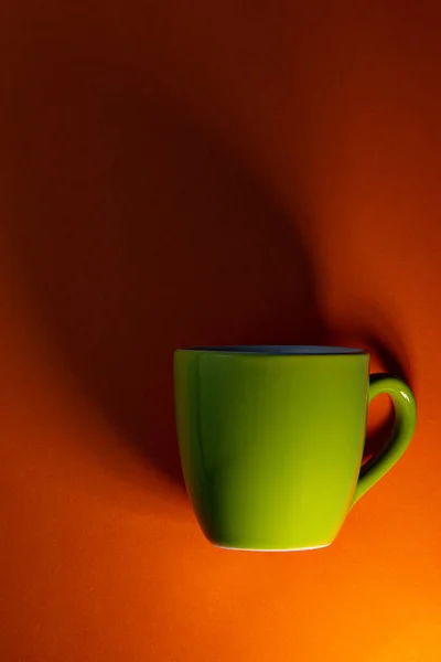 Zielony Kubek Ciemny Cień Pomarańczowym Tle Koncepcja Biznesu Pokrycie — Zdjęcie stockowe
