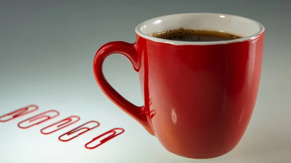Czerwona Filiżanka Kawą Czerwonymi Spinaczami Leży Jasnym Tle Koncepcja Biznesu — Zdjęcie stockowe