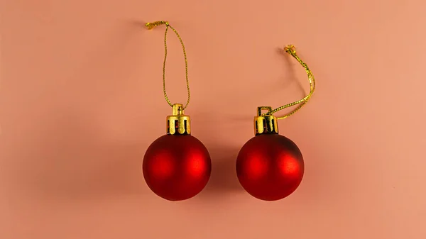 一对圣诞红球 粉色背景上有金丝绳 节日背景 — 图库照片