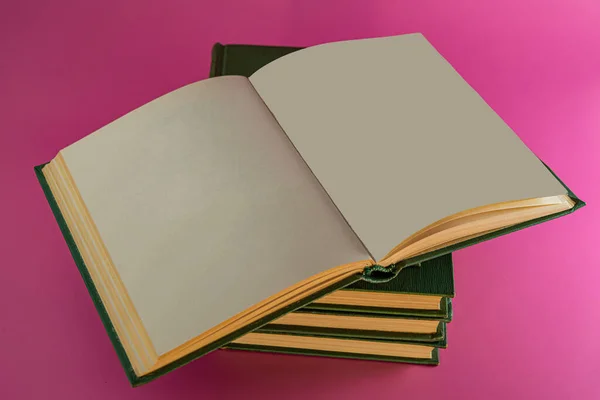 翻开的书躺在一堆粉色背景的书上 业务概念 — 图库照片