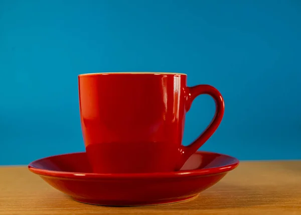 Rote Tasse Einer Untertasse Steht Auf Einem Holztisch Vor Blauem — Stockfoto