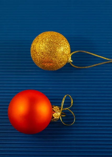 两个新年的红金球 蓝底上有金丝绳 节日背景 — 图库照片