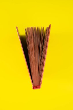 Sarı arka plan üzerine açık bir kitap, yakın plan. Tasarım için arkaplan.