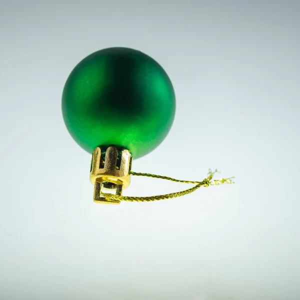 玩具新年的绿色球与金绳 躺在一个轻盈的背景上 节日背景 — 图库照片