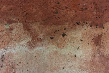 Eski beton alçı duvarın yüzeyi ve hasarlı kahverengi boya. Kentsel çevre.