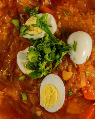 Kaynamış tavuk yumurtası dilimli Ukrayna çorbası, yakın plan. Ulusal Ukrayna yemeği.