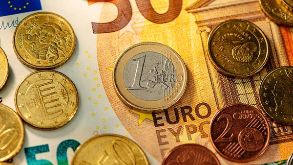 One euro coin and euro cent coins lie on a fifty euro paper note. Business concept. Web banner.