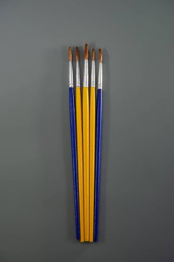 Sanatsal fırçalar koyu gri arka planda yatar. Sanat konsepti. Kapak.