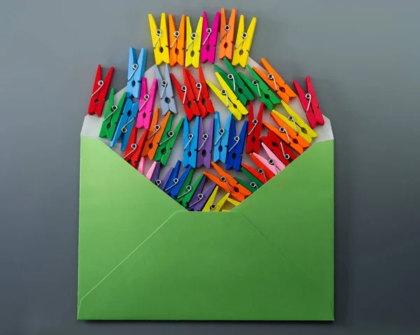 Conceptual Composition Open Green Envelope Multi Colored Clothespins Gray Background — Stock Fotó