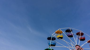 Parkta güneşli bir günde mavi gökyüzüne karşı dönme dolap. Bahar mevsimi, Mayıs. Web pankartı. 