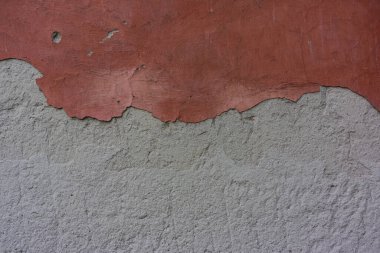 Duvardan eski kırmızı beton alçı tabakası düşüyor. Şehir çevresi. Tasarım için arkaplan.