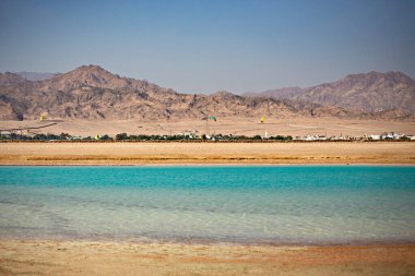 Arka planda ıssız dağlar olan boş deniz kıyısı.