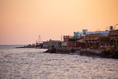 Dahab sahilinde güzel bir gün batımı, Dahab, Mısır 'da kafeler ve turuncu gökyüzü