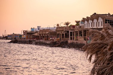 Dahab sahilinde güzel bir gün batımı, Dahab, Mısır 'da kafeler ve turuncu gökyüzü