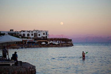 Dahab sahilinde güzel bir gün batımı, Dahab, Mısır 'da kafeler ve turuncu gökyüzü