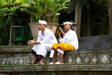 Geleneksel kıyafetler giyen Balili adam telefonda konuşuyor, Bali, Endonezya