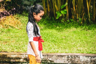  Tapınak töreni sırasında geleneksel elbiseler giyen sevimli gülümseyen Balili küçük kız, Bali, Endonezya