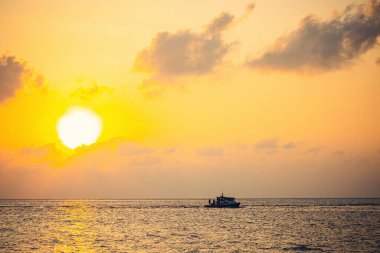 MAAFUSHI, MALDIVES - Mart 2021: Günbatımında denizde tekne, Maafushi Adası, Maldivler