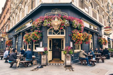 LONDON, UNITED KINGDOM - Ekim 2019: Eski geleneksel İngiliz Pub, Bira Fabrikası, Bar girişi Orta Londra, Birleşik Krallık 'ta çiçeklerle süslenmiş