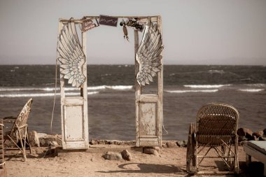 DAHAB, EGYPT - Ekim 2020: Dahab 'daki deniz kenarındaki kafede yaratıcı dekorasyon: denizin önündeki eski ahşap kapılar ve kanatlar, Dahab, Mısır