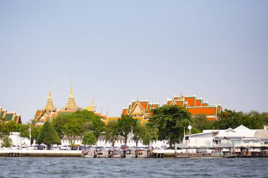 Limanda demirli tekneler ve arka planda tipik Asya binaları var.