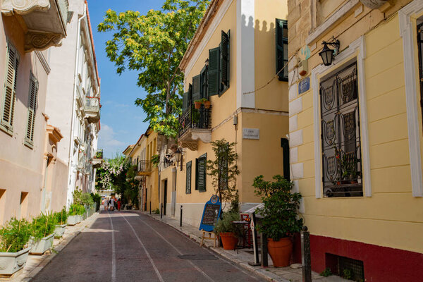 ATHENS, GREECE - July 2021: Historical narrow street and colorful buildings of Plaka, old town, Athens, Greece