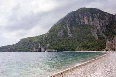 Scenic view of high green mountains with seaside