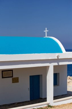 Deniz kıyısındaki küçük mavi ve beyaz kilisenin detaylı görüntüsü