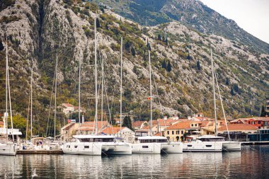 Dağların yakınındaki rıhtımda demirli lüks yatlar