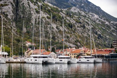 Dağların yakınındaki rıhtımda demirli lüks yatlar