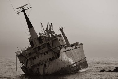 Eski kırık gemi gün batımında kıyıya demir attı.