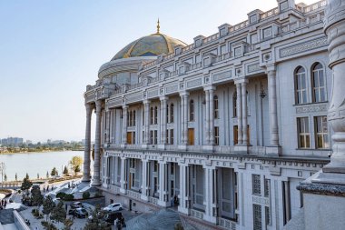 TAJIKISTAN - 20 Ağustos 2025: Dushanbe, Tacikistan 'daki Navruz Sarayı' nın görkemli manzarası, büyük sütunlar, kubbeli köşkler ve berrak mavi gökyüzü altında manzaralı göl manzarası