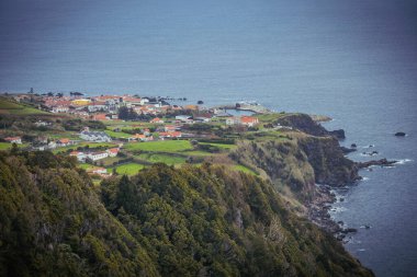 Flores adasının muhteşem manzarası yeşil tepeler ve Atlantik okyanus kıyısındaki uçurum evleri Azores Portekiz