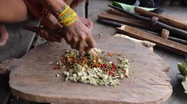 SIBERUT, INDONEZYA - 15 Kasım 2025: Geleneksel giysi ve vücut dekorasyonlarıyla Mentawai şamanı zehri Siberut Adası 'ndaki Sibirya Sumatra Endonezya' daki evinde avlanmak için hazırlıyor.