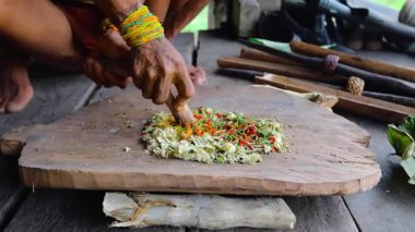 SIBERUT, INDONEZYA - 15 Kasım 2025: Geleneksel giysi ve vücut dekorasyonlarıyla Mentawai şamanı zehri Siberut Adası 'ndaki Sibirya Sumatra Endonezya' daki evinde avlanmak için hazırlıyor.