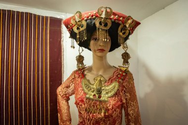 BERASTAGI, INDONESIA - 15 Kasım 2025: Berastagi Kuzey Sumatra Endonezya 'daki Karo kabilesi müzesinde geleneksel Karo kabile kıyafeti sergisi