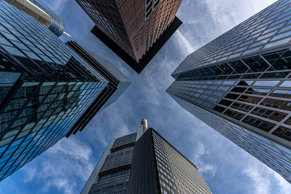 Low angle view of four skyscrapers with different facade designs under the blue sky, Frankfurt, Hessen