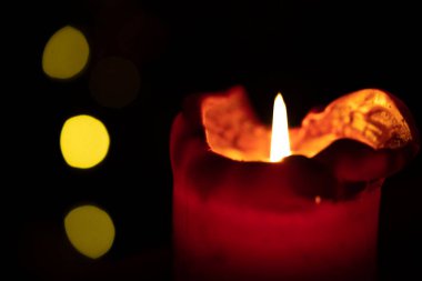 Kırmızı yuvarlak mum arka planda Bokeh ışıkları yanıyor.