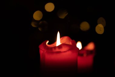 Kırmızı yuvarlak mum arka planda Bokeh ışıkları yanıyor.