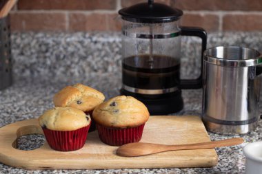 Mutfak tahtasına sarılı taze pişmiş yaban mersinli çörekler.