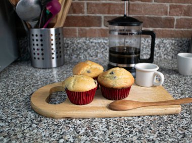 Mutfak tahtasına sarılı taze pişmiş yaban mersinli çörekler.