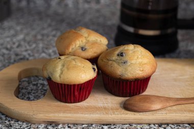 Mutfak tahtasına sarılı taze pişmiş yaban mersinli çörekler.