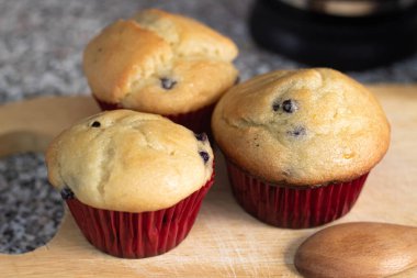 Mutfak tahtasına sarılı taze pişmiş yaban mersinli çörekler.