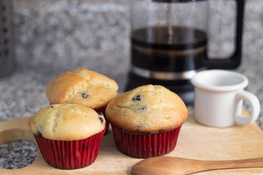 Mutfak tahtasına sarılı taze pişmiş yaban mersinli çörekler.