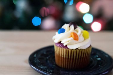 Buzlu kek, ahşap bir masa ve arka planda biraz sigara.